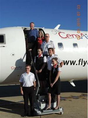 Five flycemair experience crew and others pose for a photo-shoot on flycemair superior aircraft airstair